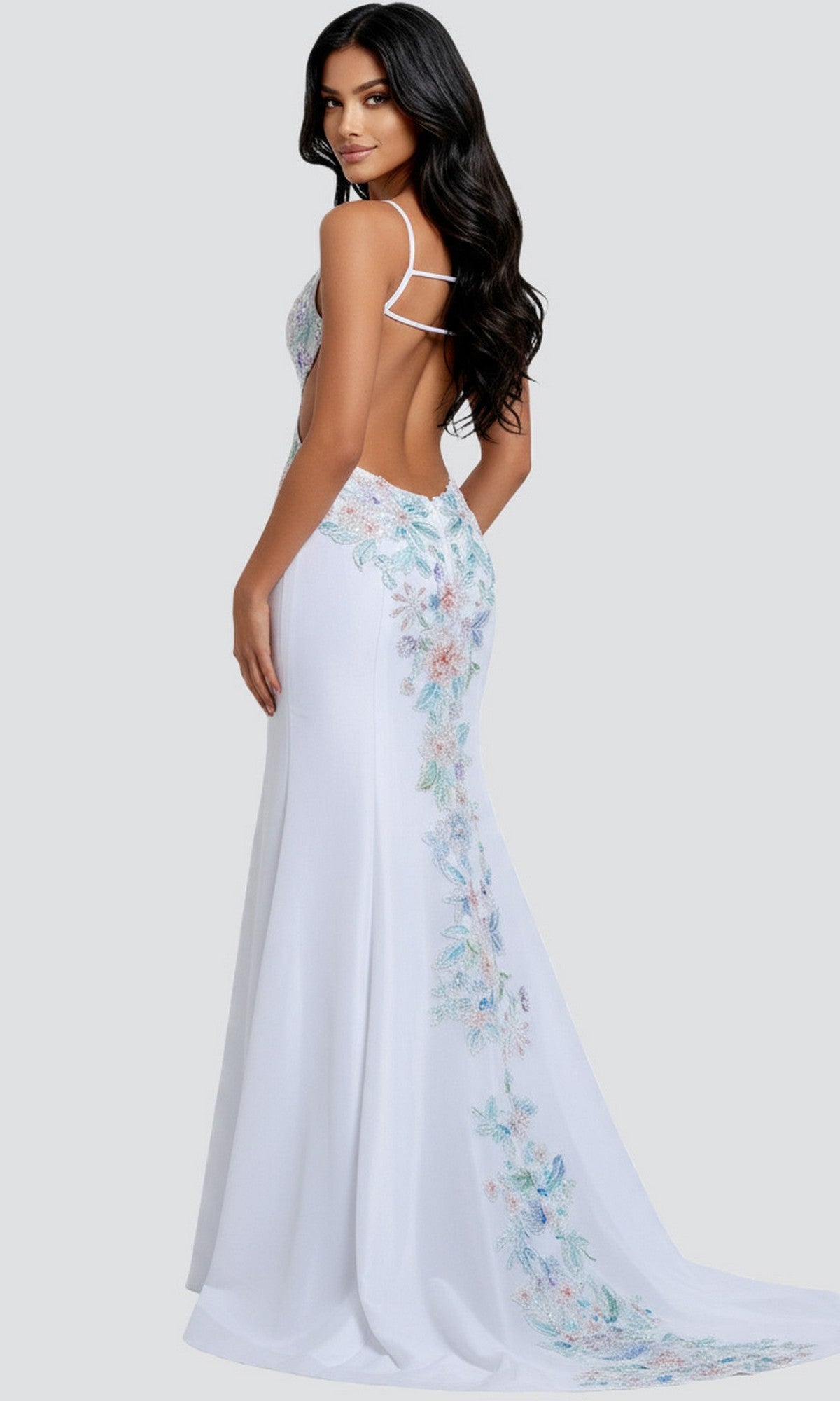 A woman wears the Jovani 48176 Long Prom Dress—a white, floor-length gown with thin straps and pastel floral embroidery—posed against a plain light gray background.